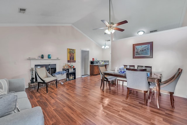 dining space featuring high vaulted ceiling, ceiling fan with notable chandelier, crown molding, and hardwood / wood-style floors