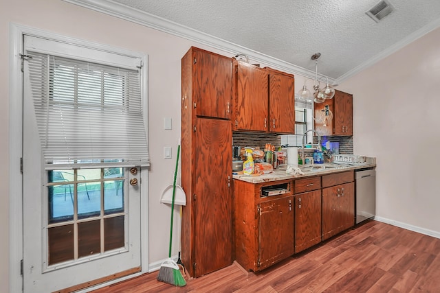 kitchen featuring backsplash, stainless steel dishwasher, hardwood / wood-style flooring, sink, and ornamental molding