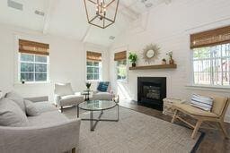 living room featuring beam ceiling, wood-type flooring, high vaulted ceiling, and a healthy amount of sunlight