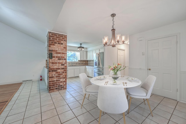 tiled dining room with a chandelier