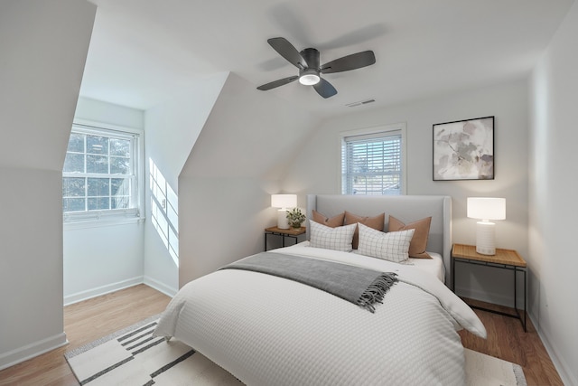 bedroom with ceiling fan, light hardwood / wood-style flooring, and lofted ceiling