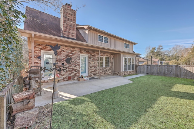 rear view of property featuring a patio and a yard