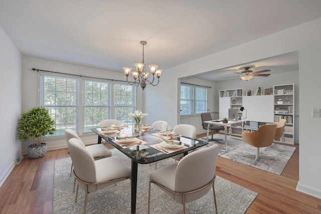 dining room with ceiling fan with notable chandelier and wood-type flooring