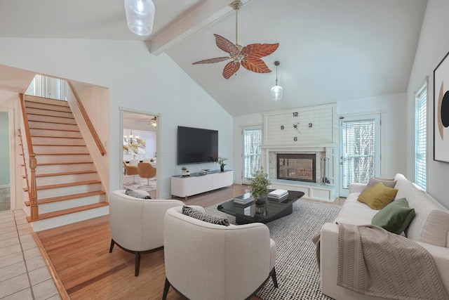 tiled living room featuring ceiling fan, beam ceiling, and high vaulted ceiling