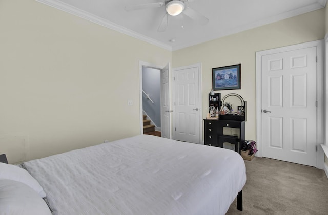 carpeted bedroom with ceiling fan and ornamental molding