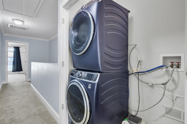 clothes washing area featuring light colored carpet, stacked washer and clothes dryer, and ornamental molding