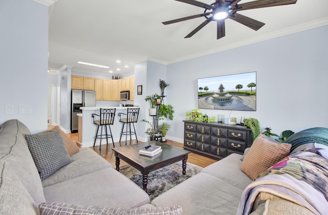 living room with crown molding, light hardwood / wood-style flooring, and ceiling fan