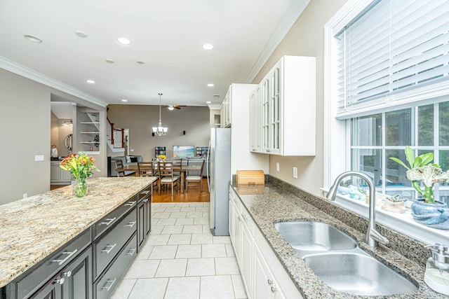 kitchen featuring pendant lighting, white cabinetry, and sink