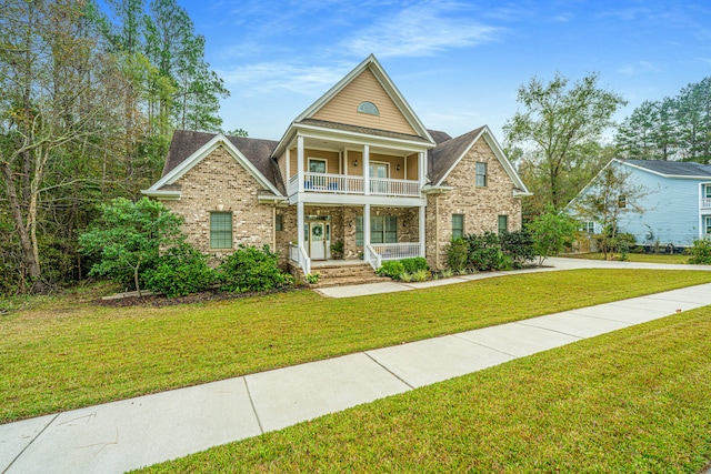 view of front of property featuring a porch, a balcony, and a front lawn