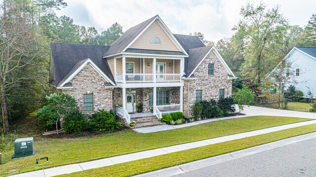 craftsman inspired home featuring a porch, a balcony, and a front yard