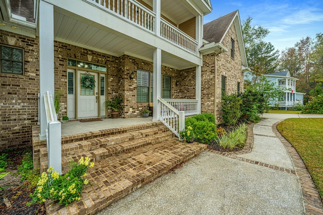 view of exterior entry featuring covered porch