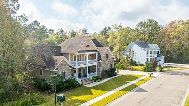 view of front facade featuring a front yard, a balcony, and a garage