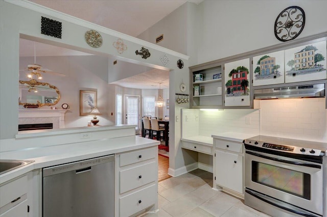 kitchen featuring white cabinetry, vaulted ceiling, appliances with stainless steel finishes, pendant lighting, and backsplash