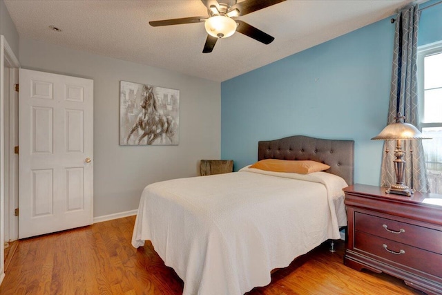 bedroom with ceiling fan, lofted ceiling, and wood-type flooring