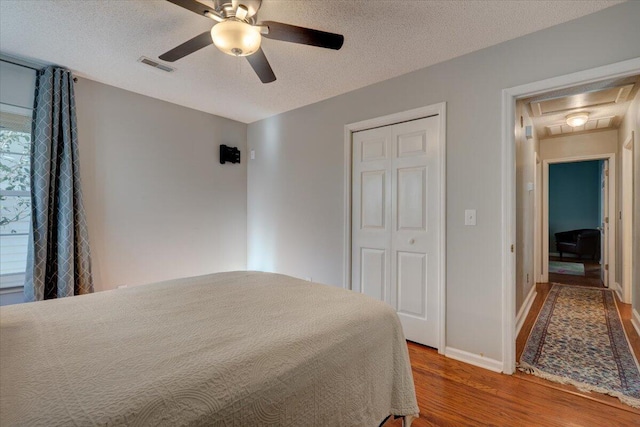 bedroom featuring hardwood / wood-style floors, a textured ceiling, and a closet