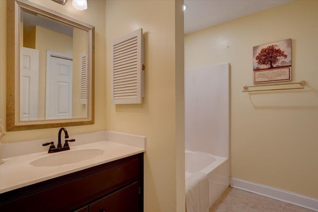 bathroom with vanity, a washtub, and tile patterned floors