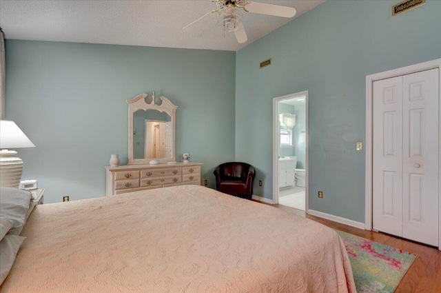 bedroom featuring lofted ceiling, ensuite bathroom, a closet, ceiling fan, and hardwood / wood-style floors