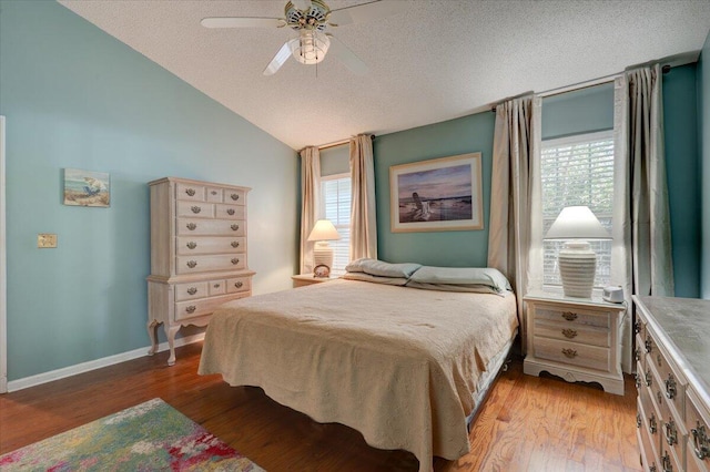 bedroom featuring multiple windows, vaulted ceiling, and light wood-type flooring