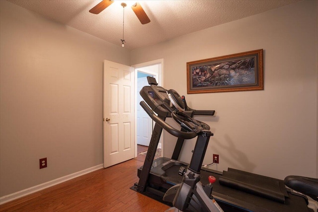 exercise area featuring hardwood / wood-style flooring, ceiling fan, and a textured ceiling