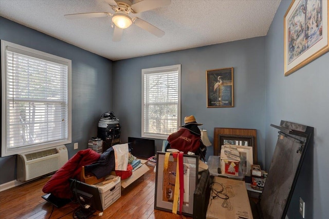 office space featuring ceiling fan, light hardwood / wood-style flooring, and a textured ceiling