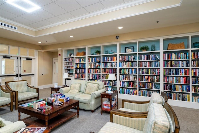 living area with carpet floors, crown molding, wall of books, and recessed lighting