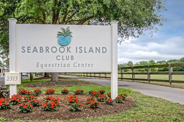 community / neighborhood sign featuring fence