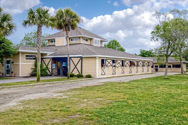 view of front of house featuring a front lawn and roof with shingles