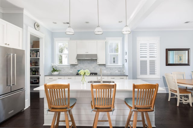 kitchen featuring hanging light fixtures, high end fridge, dark wood-type flooring, and white cabinets