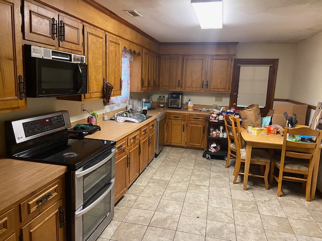 kitchen with sink, light tile flooring, and stainless steel appliances