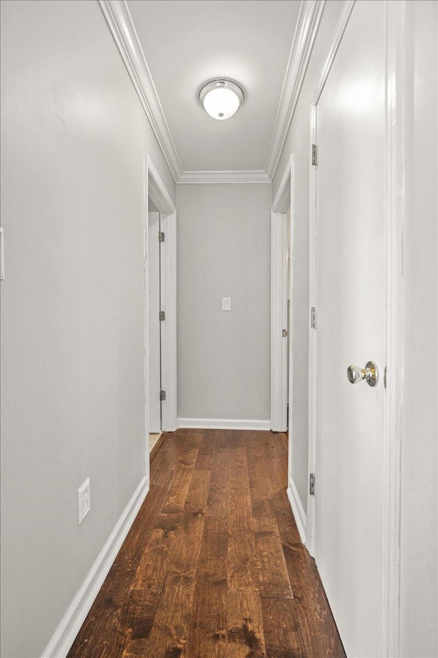 hallway with crown molding, dark wood-style flooring, and baseboards