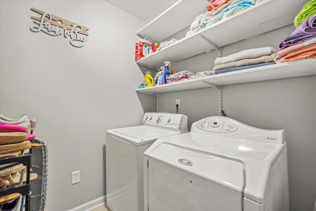 clothes washing area featuring independent washer and dryer and baseboards