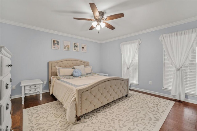 bedroom with wood finished floors, crown molding, baseboards, and ceiling fan