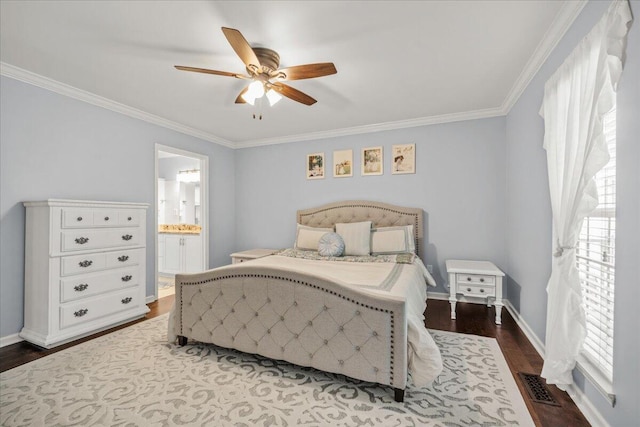bedroom featuring dark wood-style floors, crown molding, baseboards, ceiling fan, and ensuite bathroom