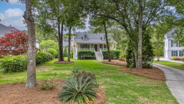 view of front of house featuring a front lawn, stairs, and covered porch