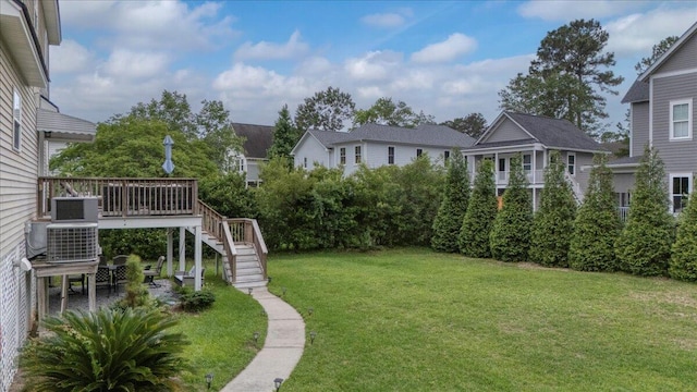 view of grassy yard with stairs and a wooden deck