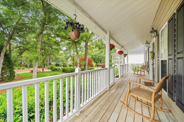 deck with a porch and view of scattered trees
