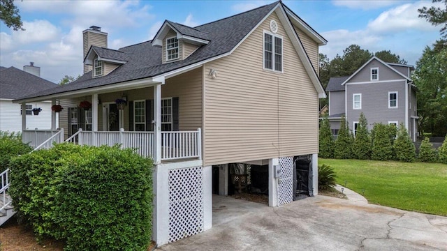 view of home's exterior with a porch, a carport, a yard, driveway, and a chimney