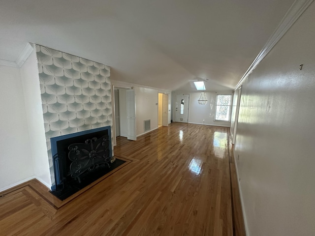 unfurnished living room featuring a fireplace, wood-type flooring, vaulted ceiling, and crown molding