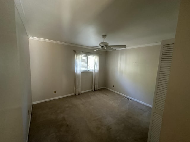 carpeted empty room with ceiling fan and crown molding