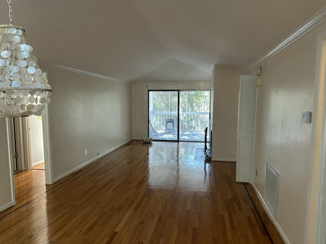 empty room with hardwood / wood-style floors, lofted ceiling, and crown molding