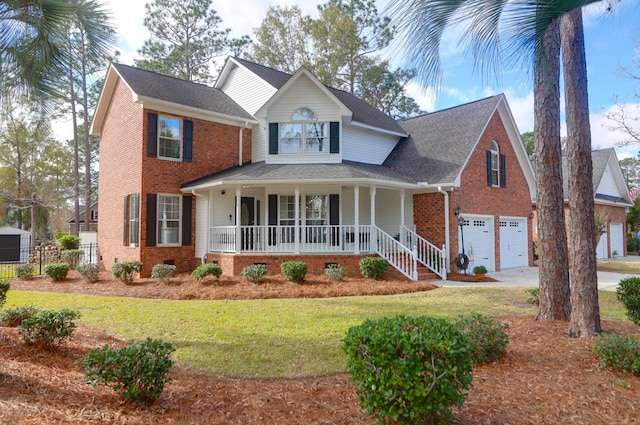 view of front of home with covered porch, a garage, and a front yard