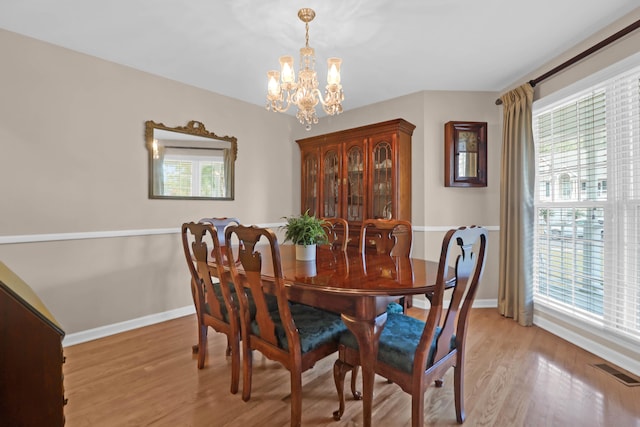 dining area featuring light wood-type flooring, an inviting chandelier, and a wealth of natural light