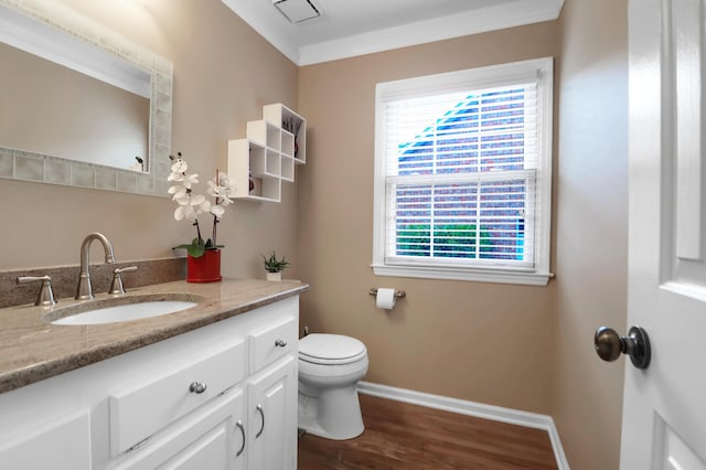 bathroom with crown molding, vanity, wood-type flooring, and toilet