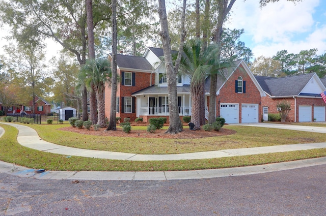 view of front of property featuring a front lawn, covered porch, and a garage