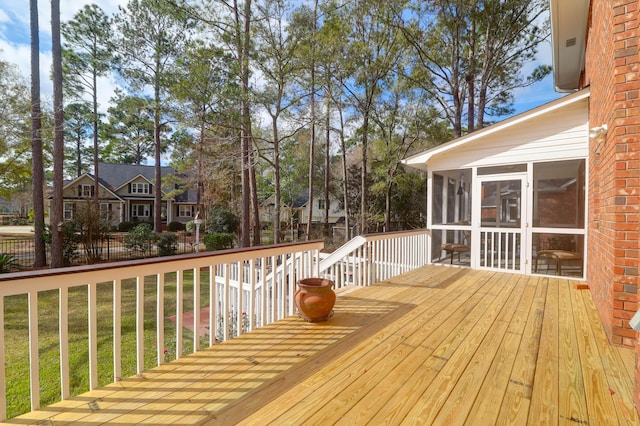 wooden terrace featuring a lawn and a sunroom