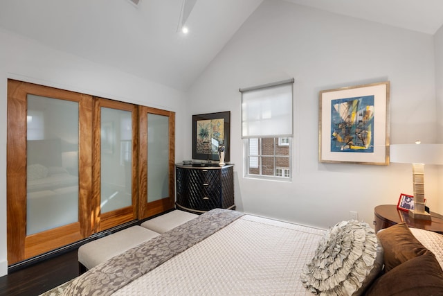 bedroom with high vaulted ceiling and wood-type flooring