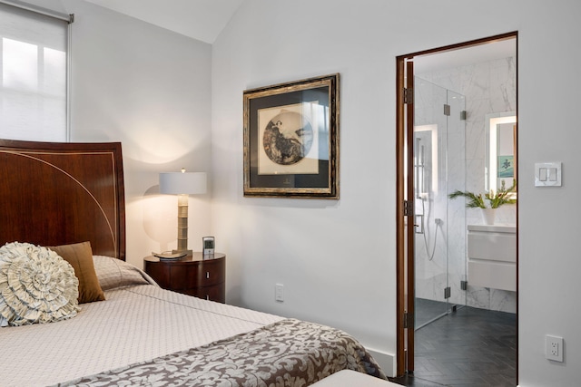 bedroom with parquet flooring, connected bathroom, and vaulted ceiling