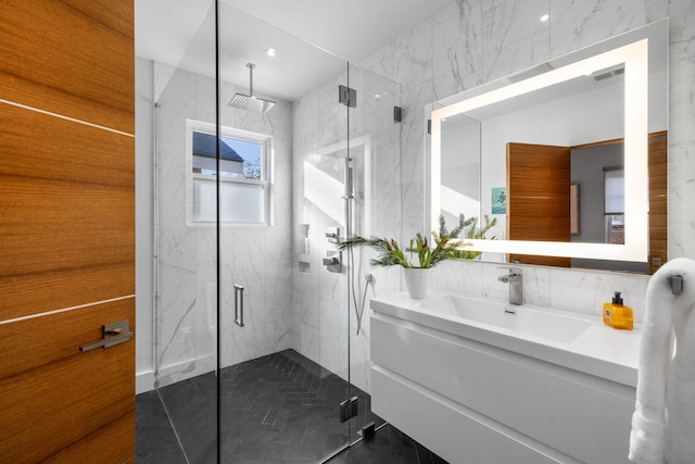 bathroom with tile walls, tile patterned floors, an enclosed shower, and vanity