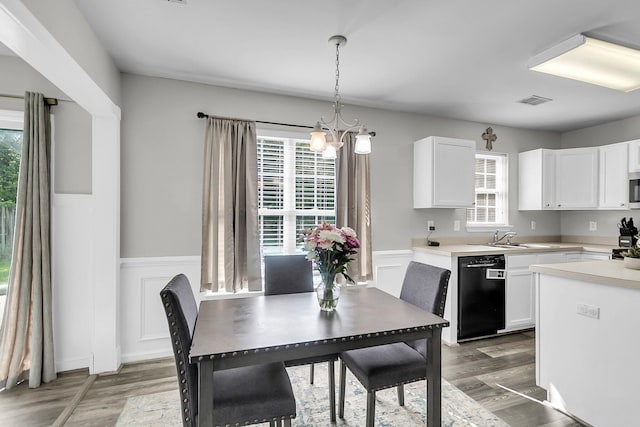 125 Towering Pine Dr, Ladson, SC 29456 - kitchen featuring black dishwasher, light wood-style floors, a wainscoted wall, white cabinets, and a sink