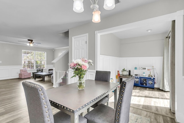 125 Towering Pine Dr, Ladson, SC 29456 - dining room with a decorative wall, a chandelier, light wood-style floors, a wainscoted wall, and ceiling fan
